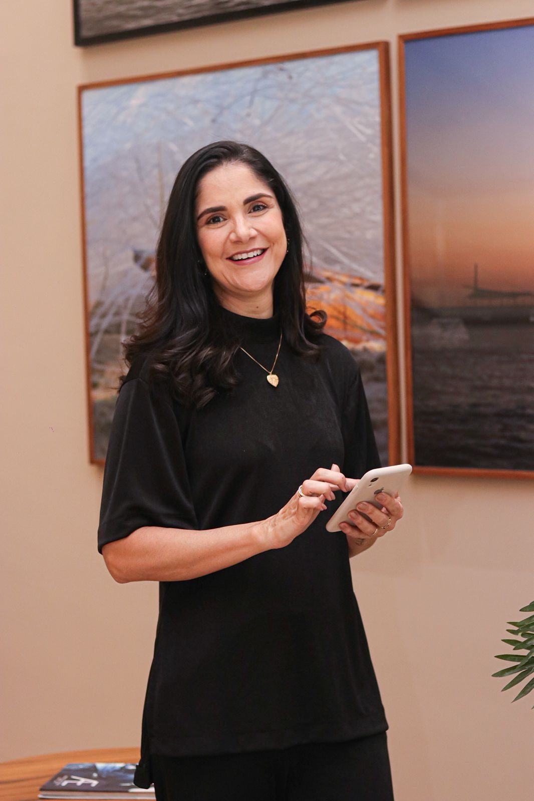 Fabíola Lacerda sorrindo com celular na mão