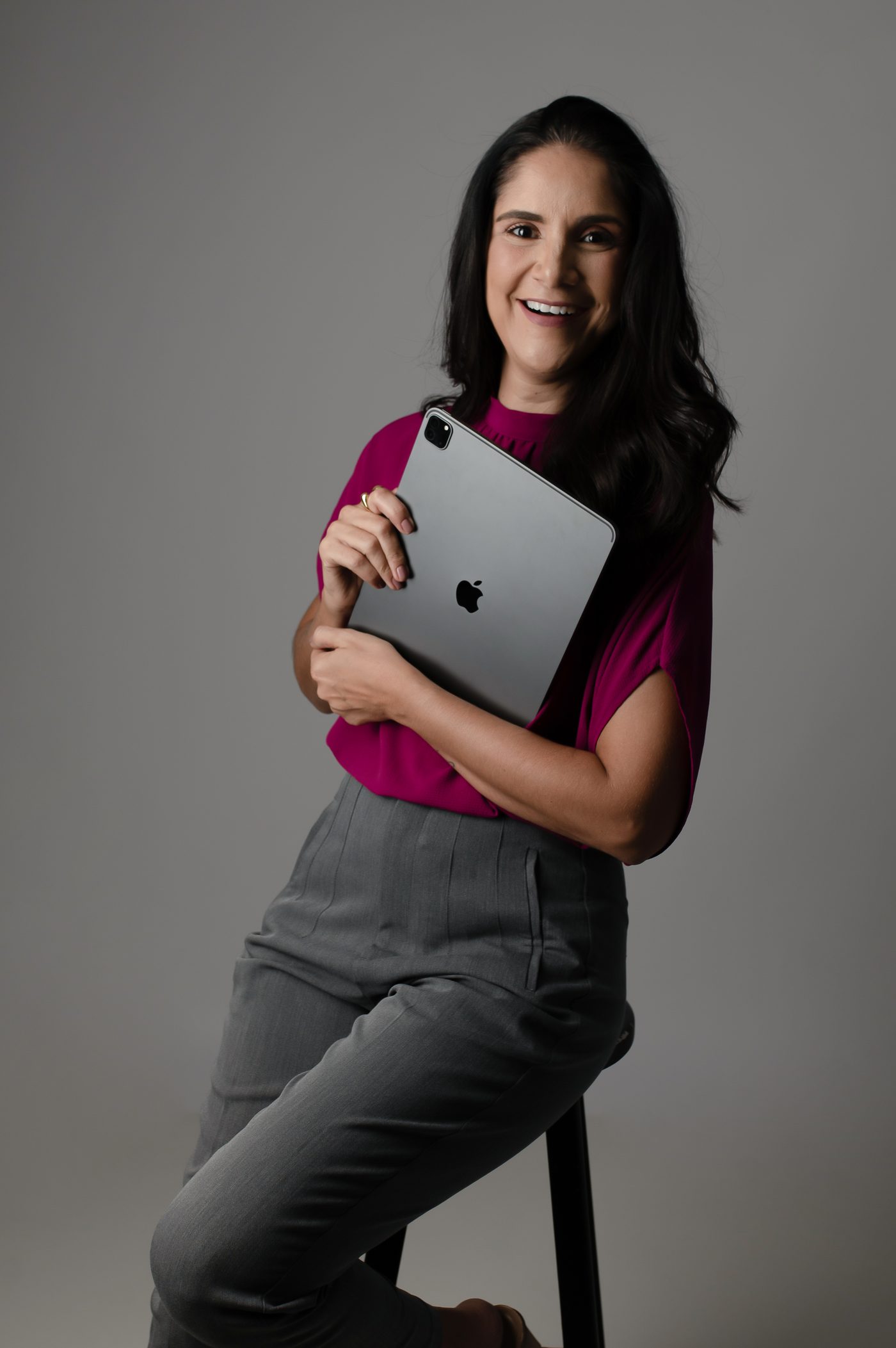 Fabíola Lacerda segurando um tablet, sorrindo